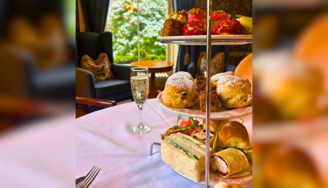 Afternoon Tea pictured in the manor with three plate tiers and some sweet and savoury treats on each plate with a glass of prosecco. | Tulfarris Hotel & Golf Resort