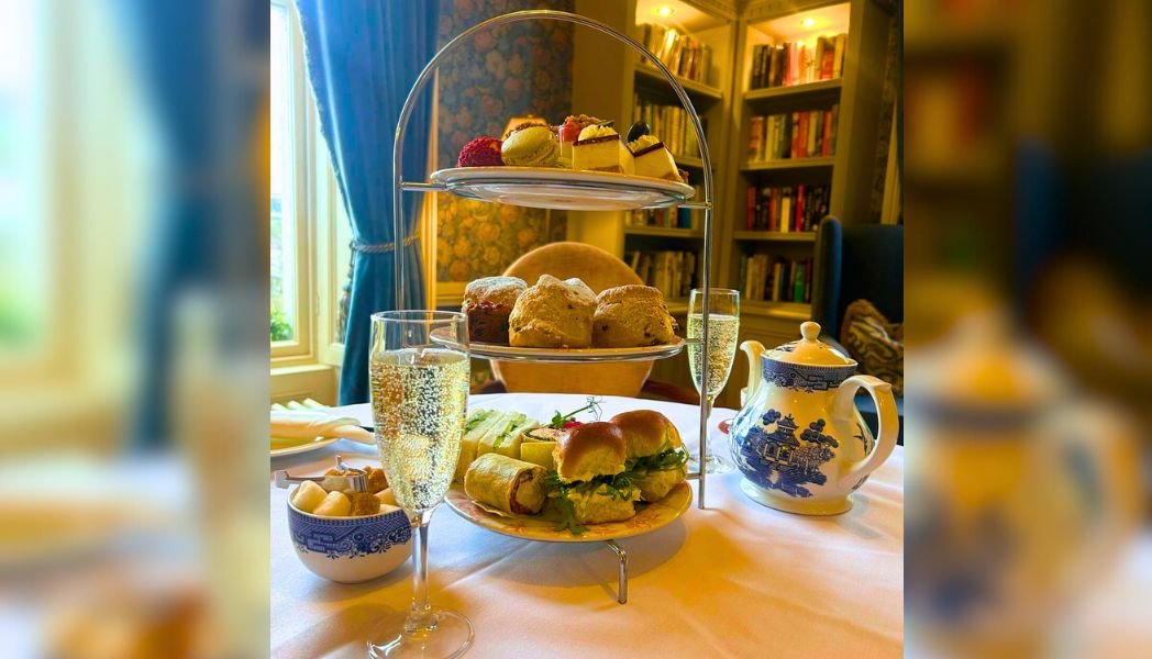 Afternoon Tea pictured in our Manor with two glasses of bubbly prosecco with some sweet and savoury treats on a three tier plate