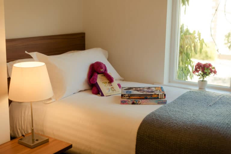 Tulfarris Hotel & Golf Resort Holiday Lodge books & teddy bear on single bed and flowers by the window